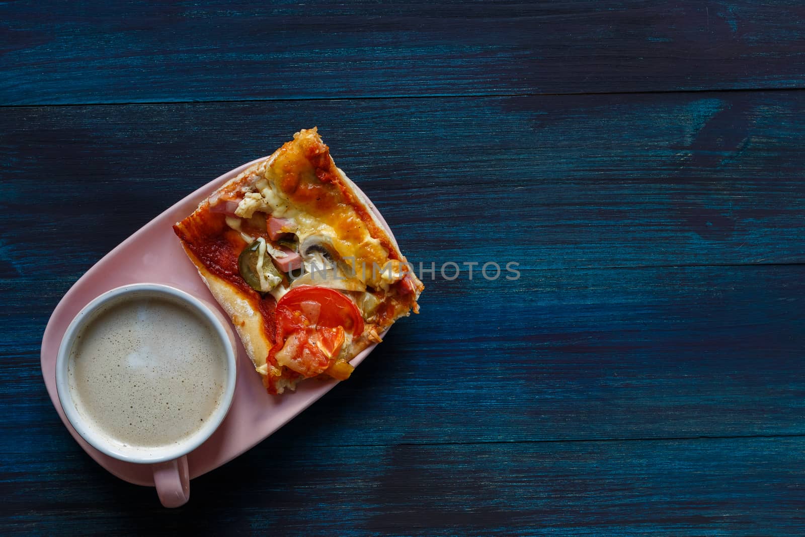 Homemade thin-crust pizza with tomatoes, mushrooms and pickled cucumbers with parmesan and cup of coffee on a dark wooden background, top view