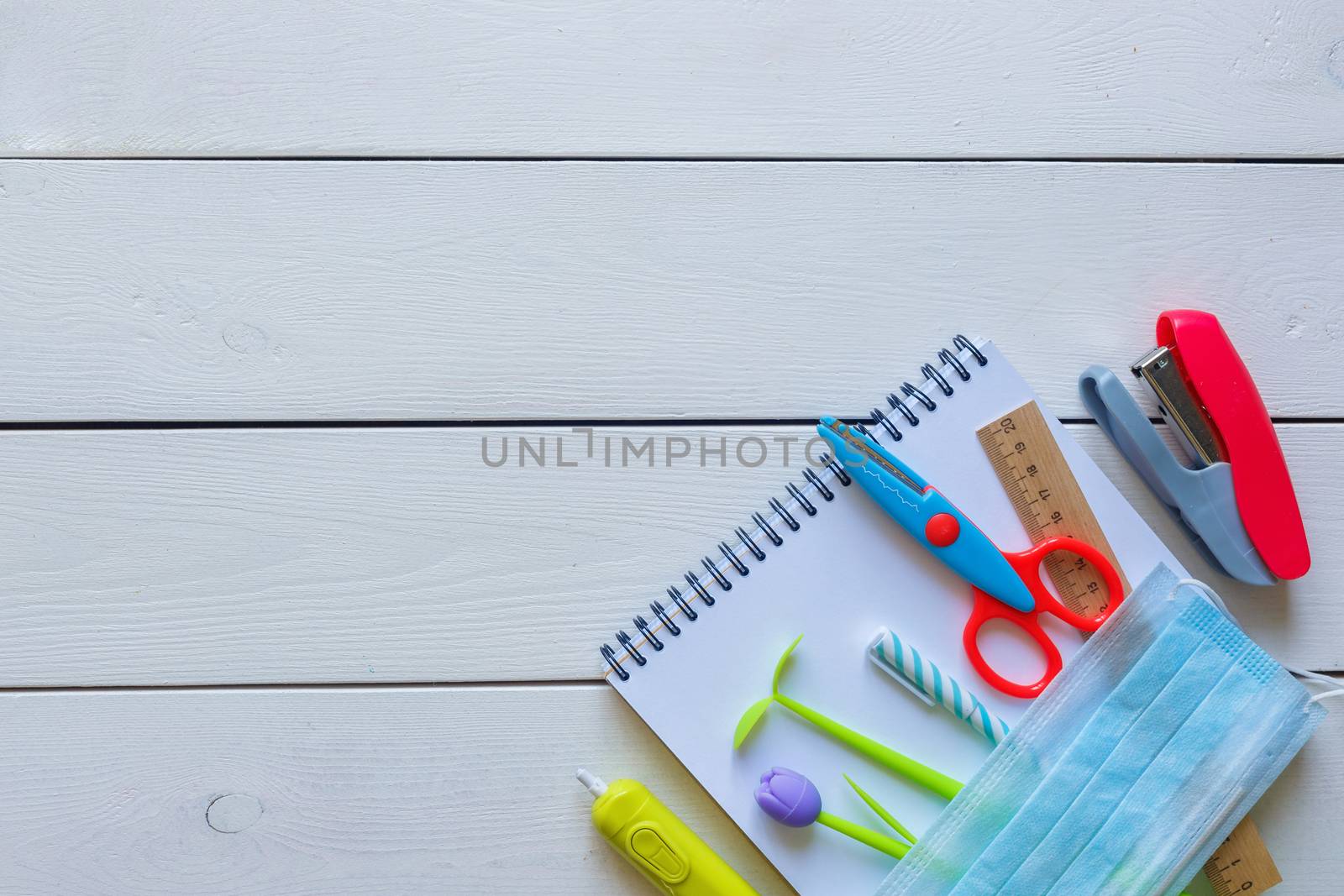 Back to school concept school office supplies on a white wooden background copy space. Education during self isolation on quarantine. Coronavirus concept.