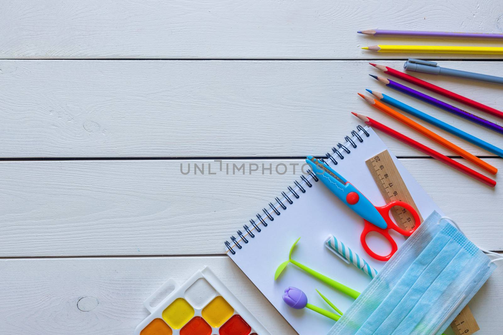 Back to school concept school office supplies on a white wooden backgrounf copy space. Education during self isolation on quarantine. Coronavirus concept.