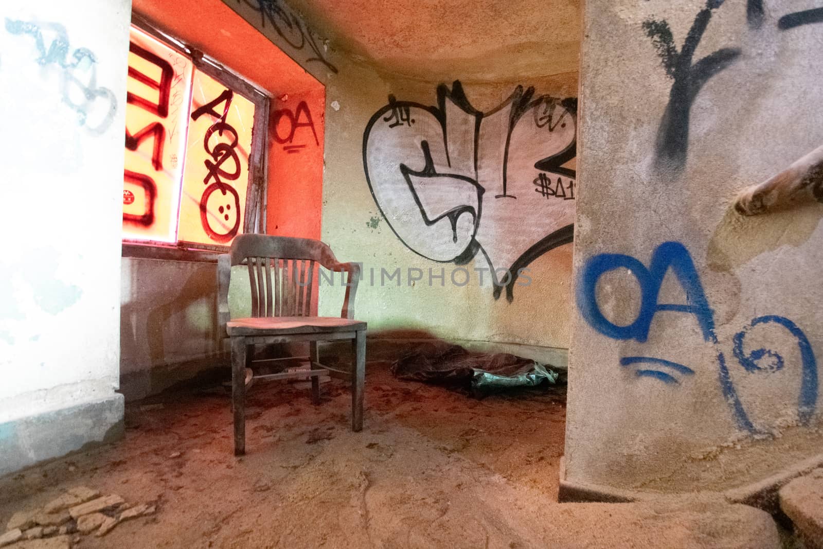 A Chair Inside an Abandoned Building Full of Debris and Dust by bju12290