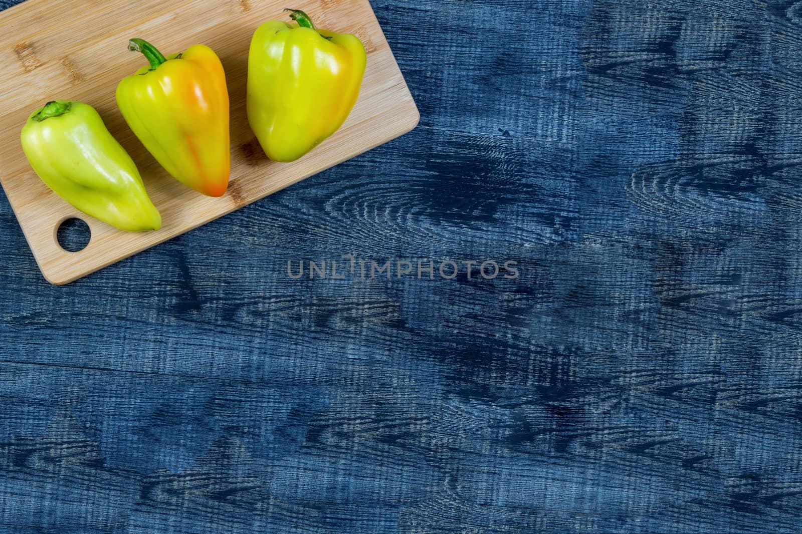 High Angle Still Life View of bell pepper on Wooden Cutting Board on Rustic Wood Table