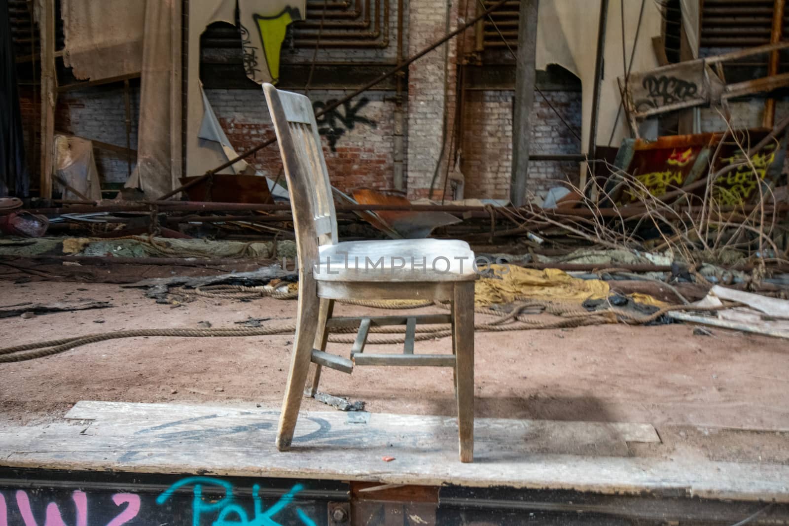 An Old and Broken Wooden Chair on the Stage of an Abandoned Theatre