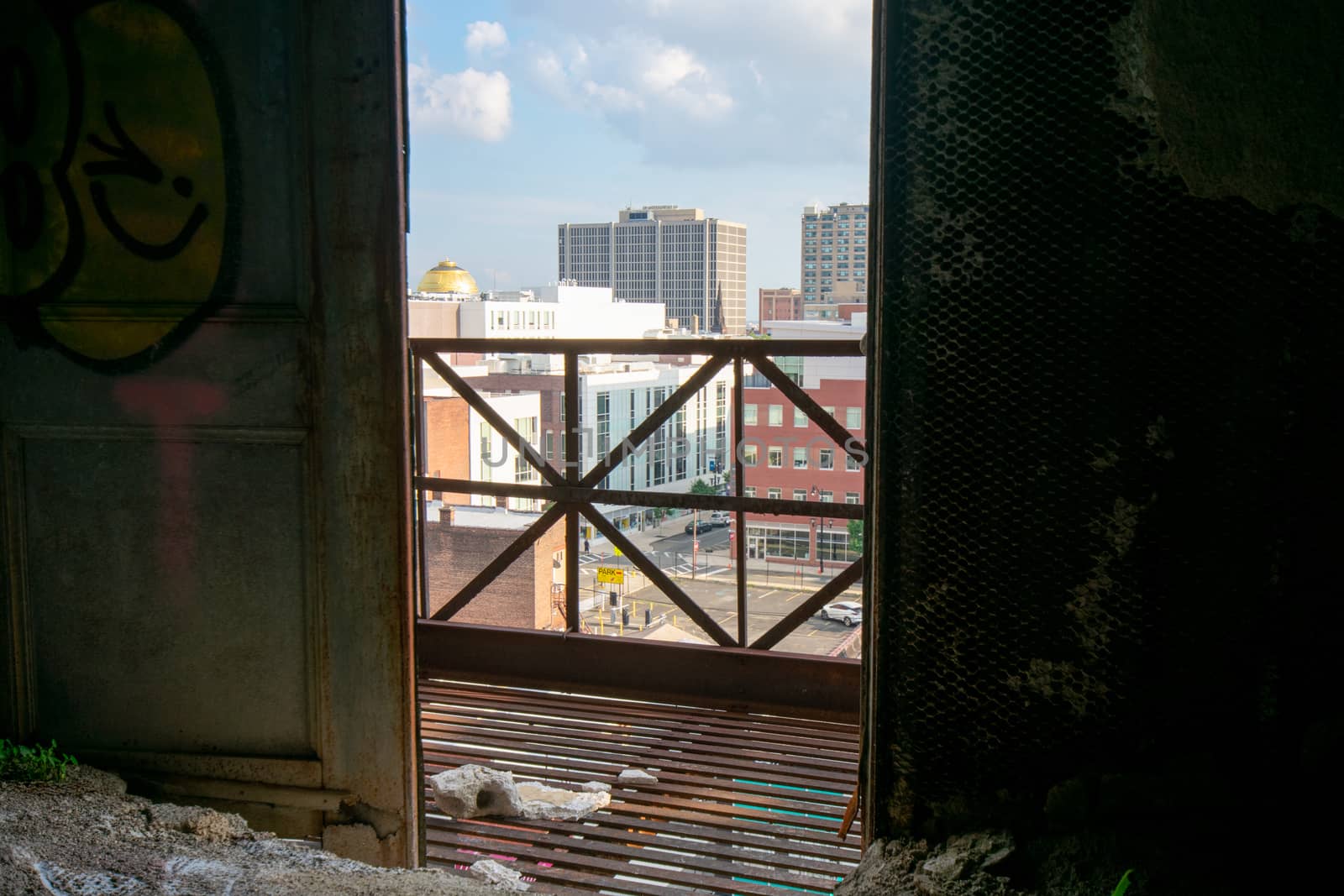 Looking Out an Open Door in an Abandoned Building at a City Skyl by bju12290