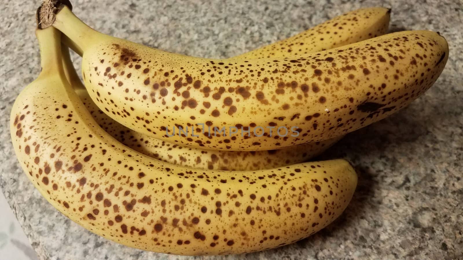 ripe banana fruit with spots on counter by stockphotofan1