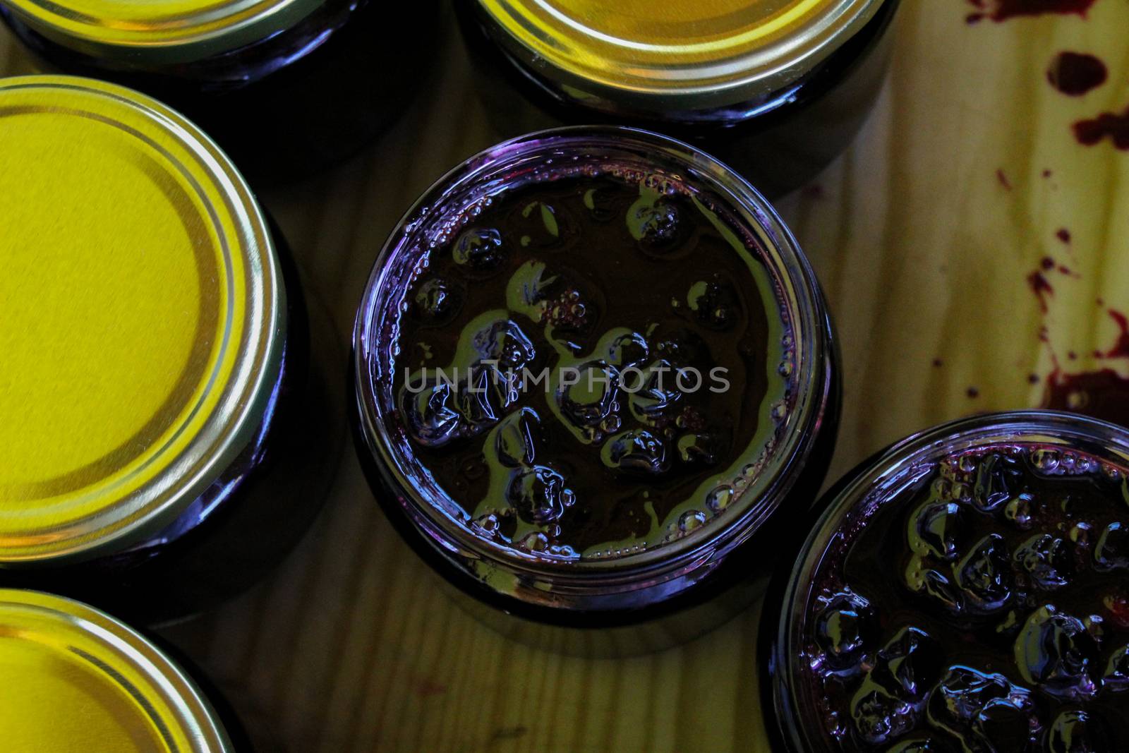 Homemade chokeberry jam in jars. Full jars of homemade chokeberry jam on a tray. Aronia jam. Zavidovici, Bosnia and Herzegovina.