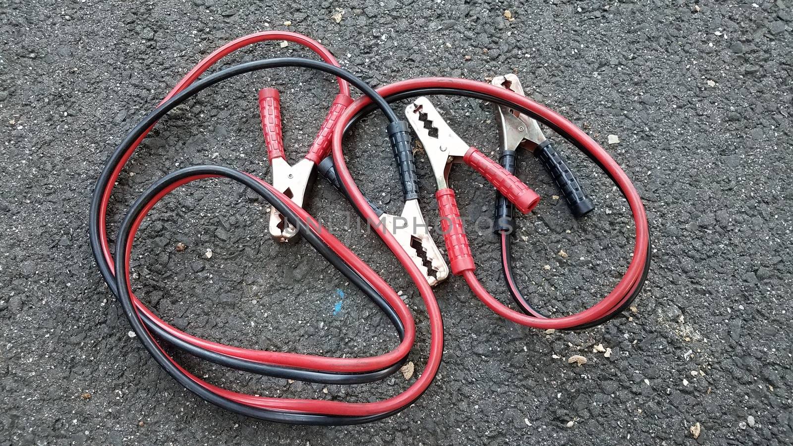 red and black metal jumper cables on ground