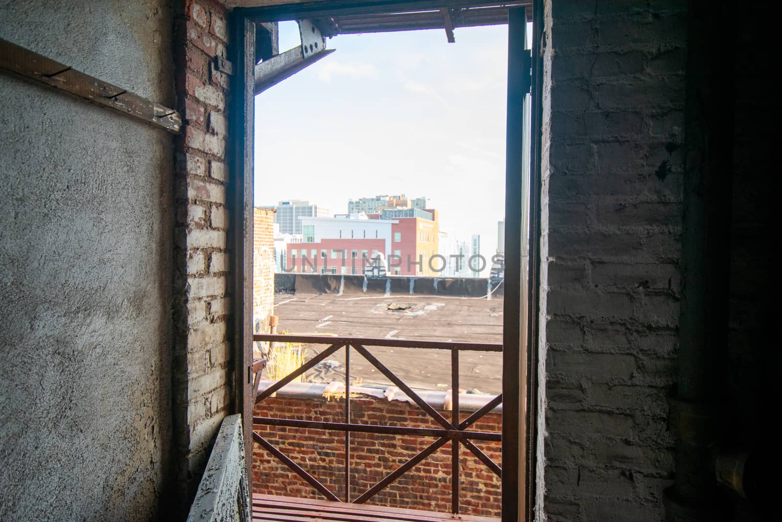 Looking Out an Open Door of an Abandoned Building Over a Fire Escape at a City Skyline