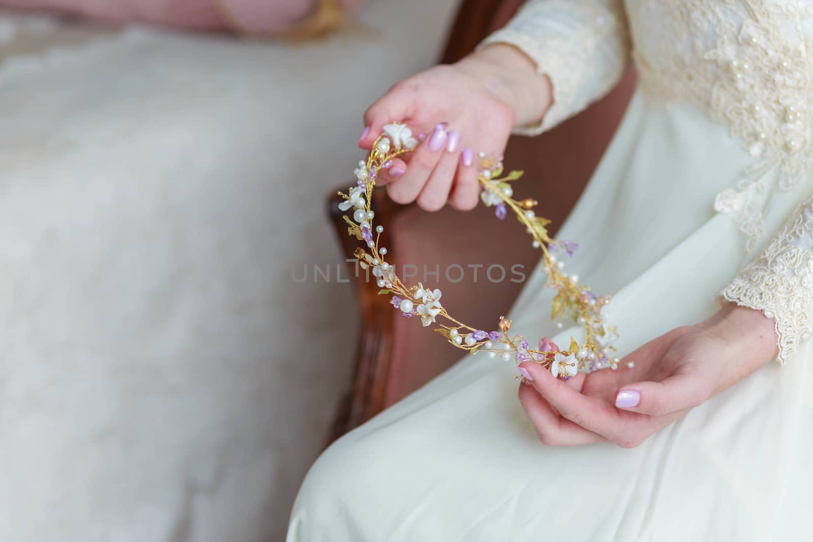 Close-up of bride's hands with hair ornament for wedding hairstyle by galinasharapova