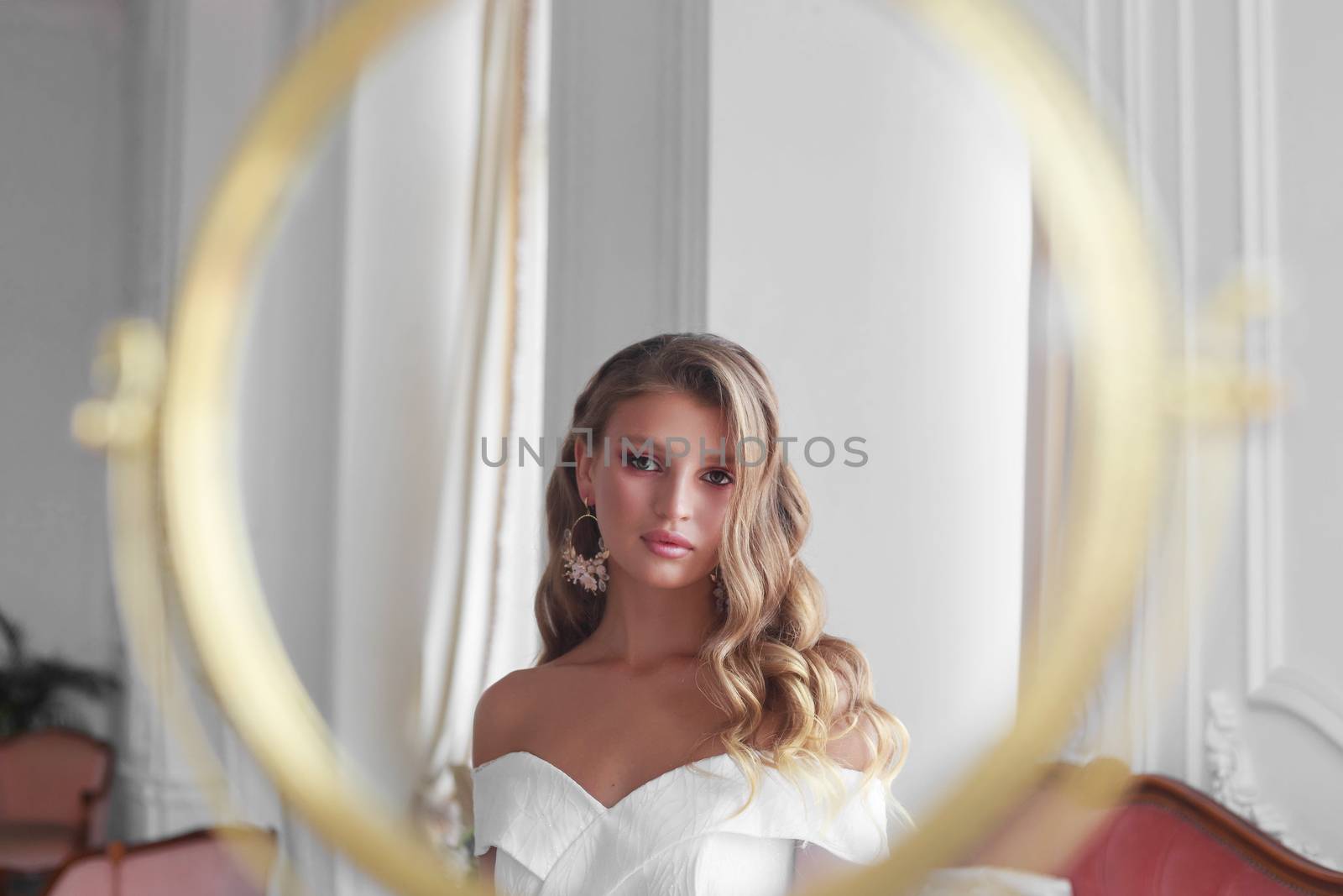 Close-up of a bride looking in a mirror before wedding ceremony.