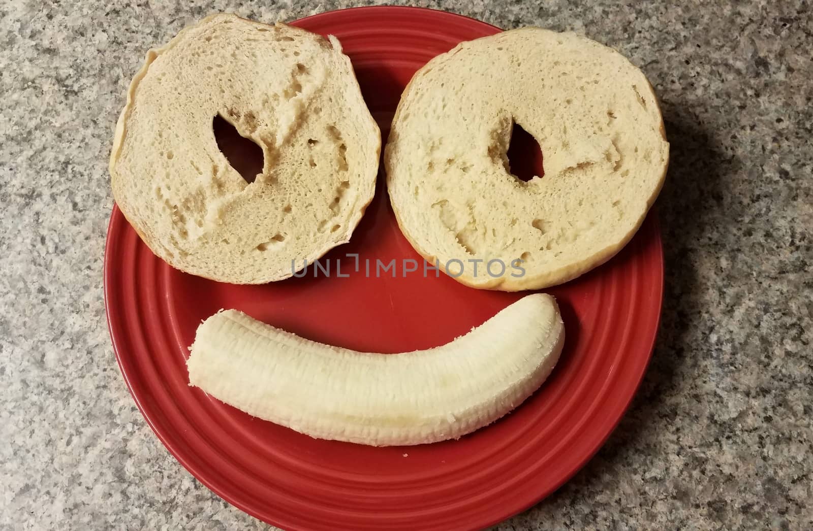 smiling face with bagels and banana on red plate