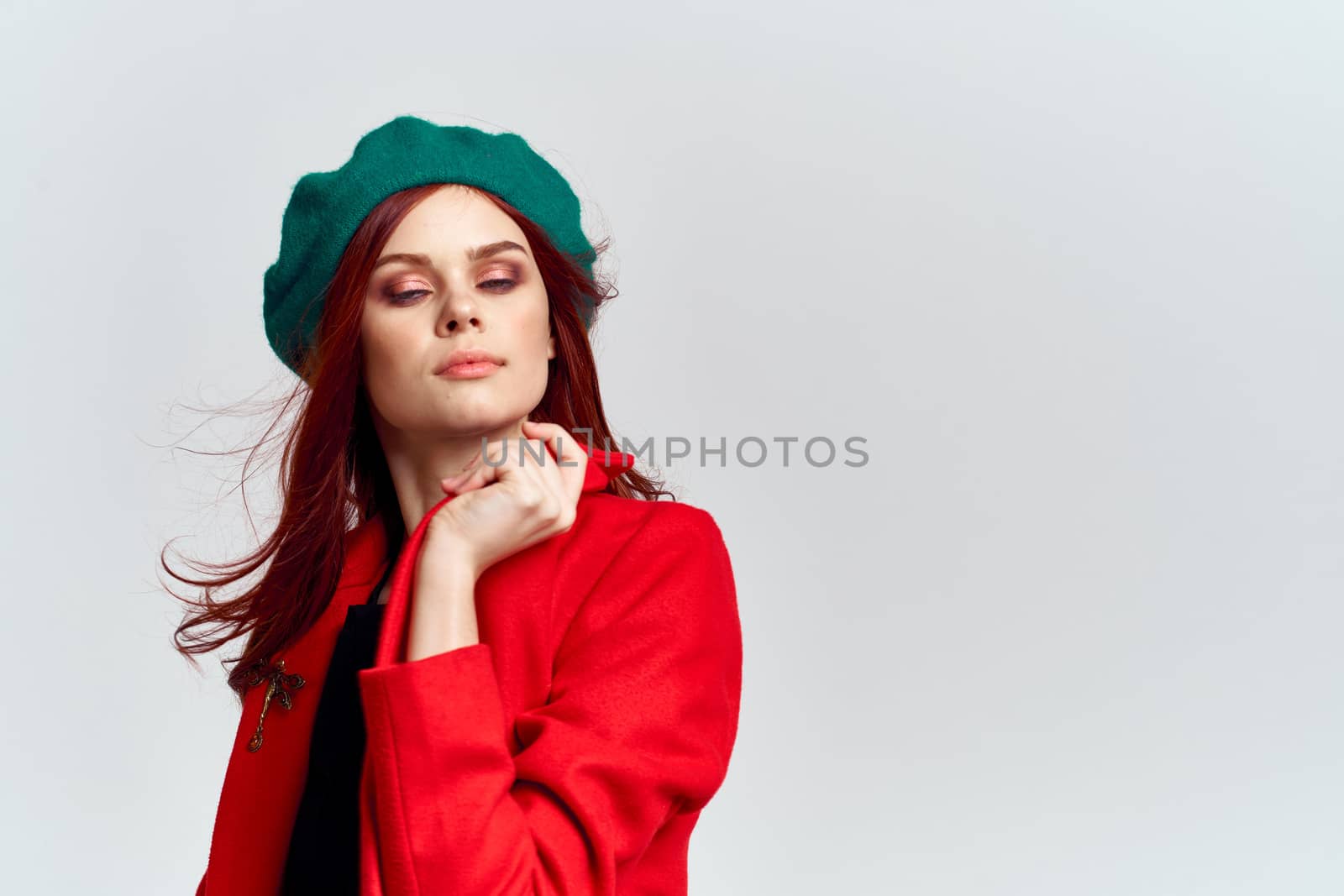 Woman in red coat and in green hat on isolated background cropped model with Copy Space emotions by SHOTPRIME