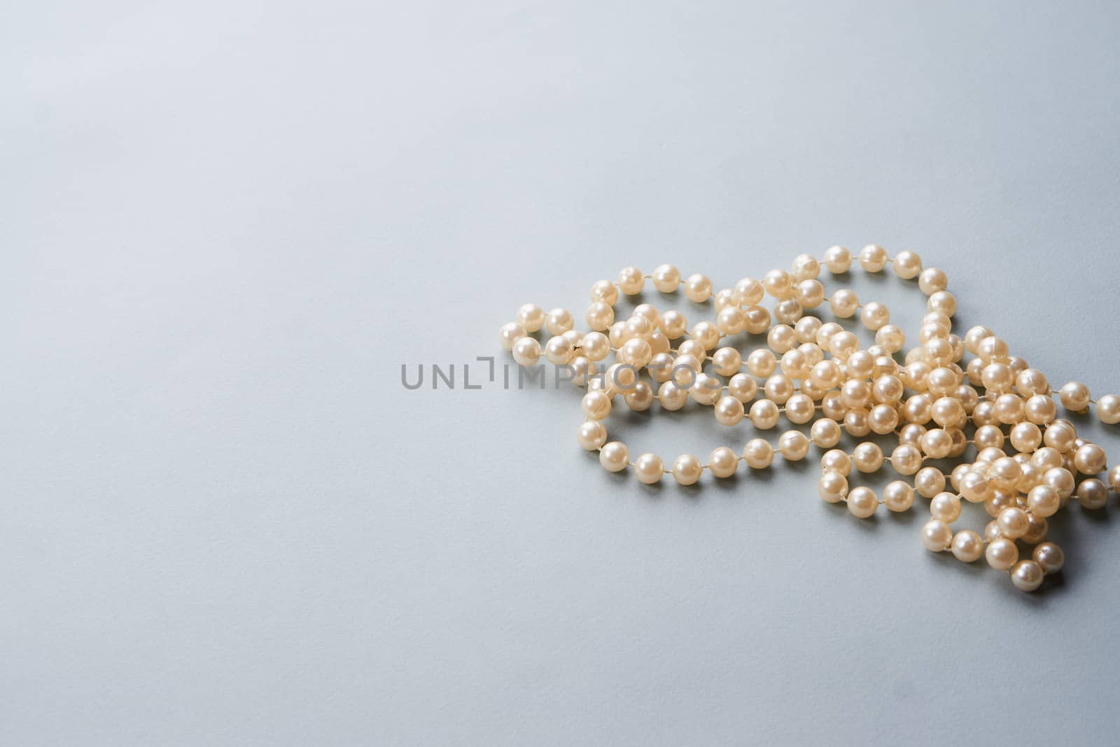 Pearl beads on a gray background decoration decoration top view by SHOTPRIME