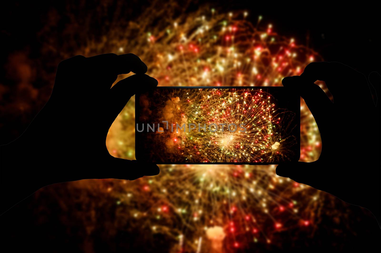 Taking the photo of fireworks via smartphone. Broadcast salute video to the internet. by 9parusnikov