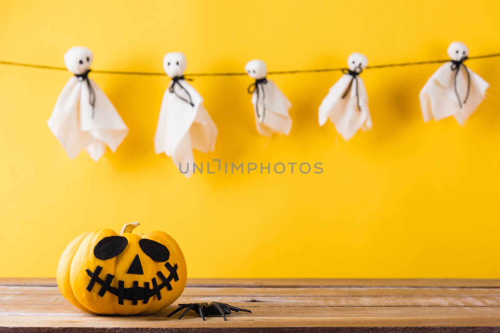 Funny Halloween day decoration party, Baby cute white ghost crafts scary face hanging and halloween pumpkin head jack lantern smile and spider on wooden, studio shot isolated, Happy holiday concept