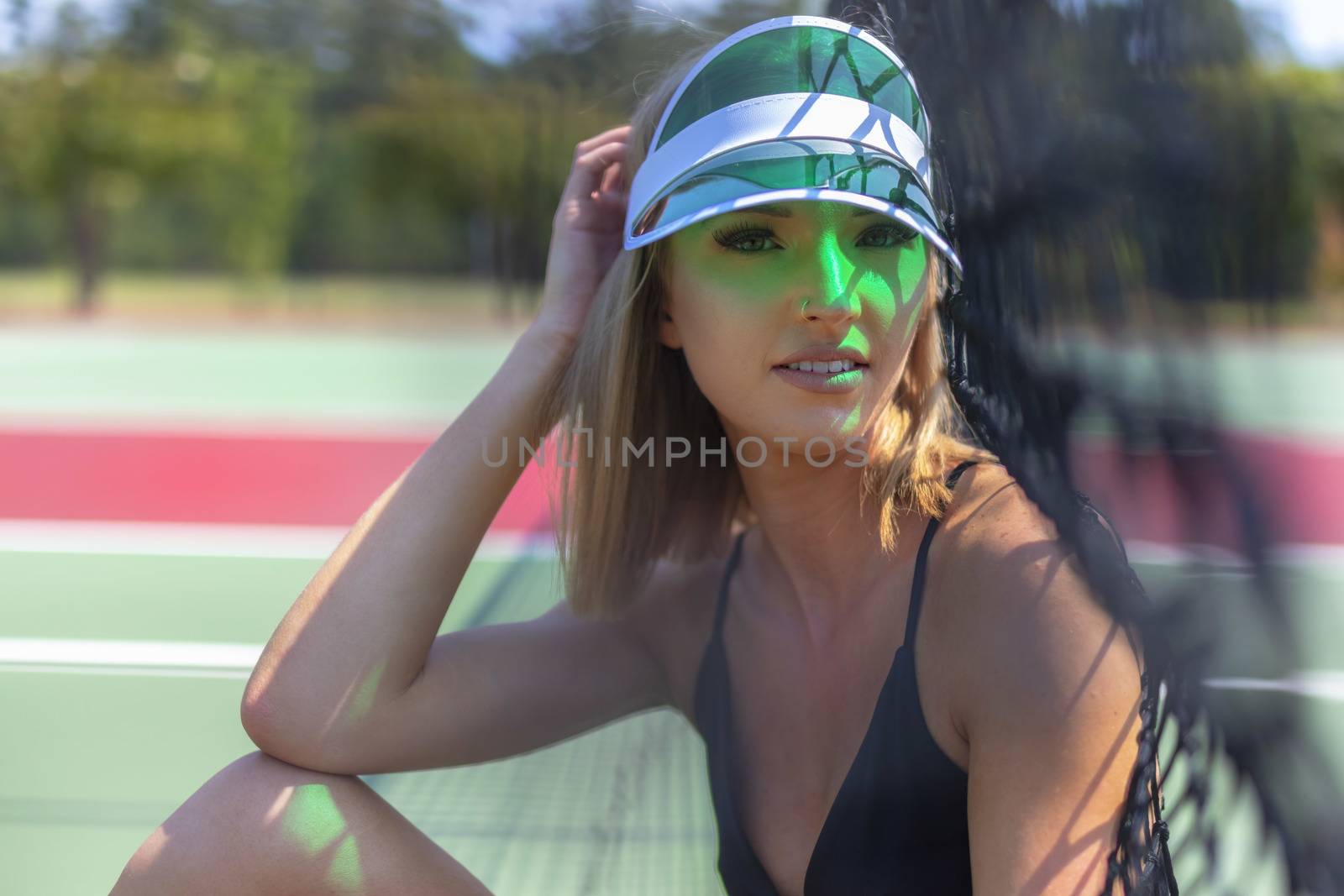 A beautiful blonde model plays tennis on a hot summers day