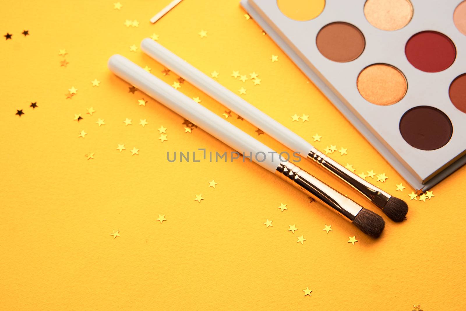 Eyeshadows on a yellow background professional cosmetics makeup brushes soft sponge fashion glasses by SHOTPRIME