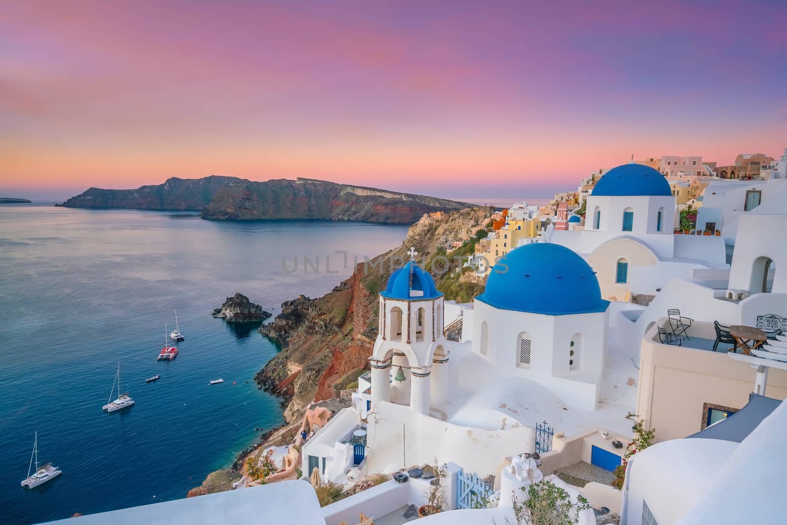 Oia town cityscape at Santorini island in Greece at sunset. Aegean sea