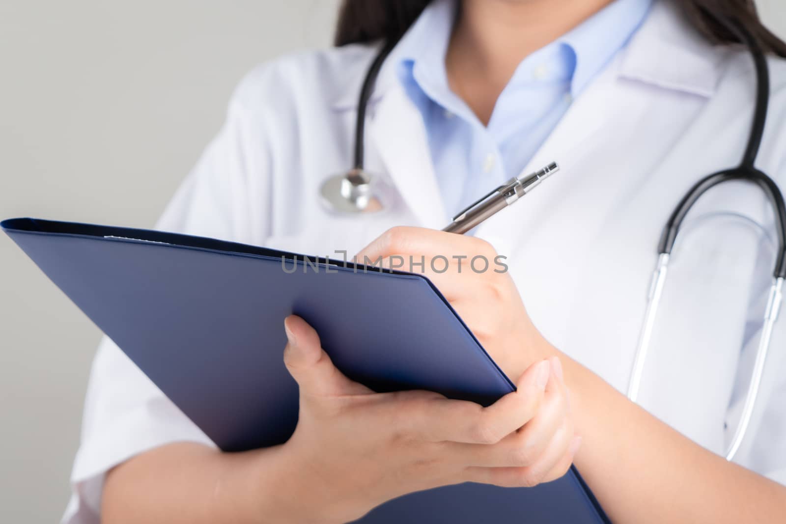 female doctor writing medical information in notebook at hospital