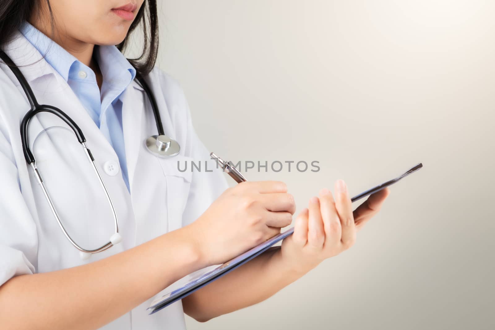 female doctor writing medical information in notebook at hospital