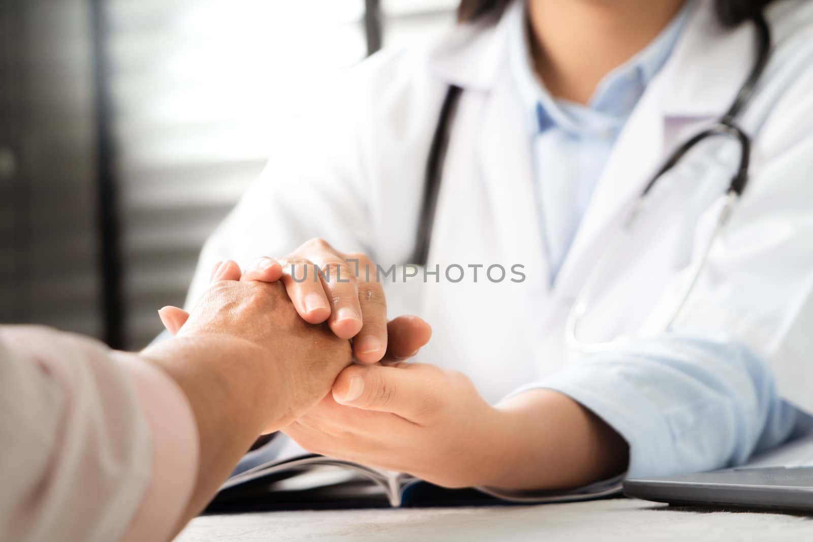 Doctor hands together holding senior woman patient