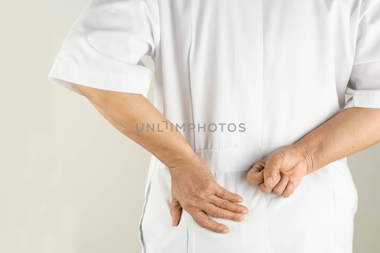 senior doctor woman suffering of backache, touching back with hand, muscular pain over white background