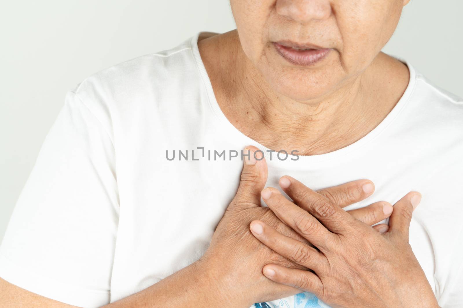 Old woman heart attack holding breast on white background