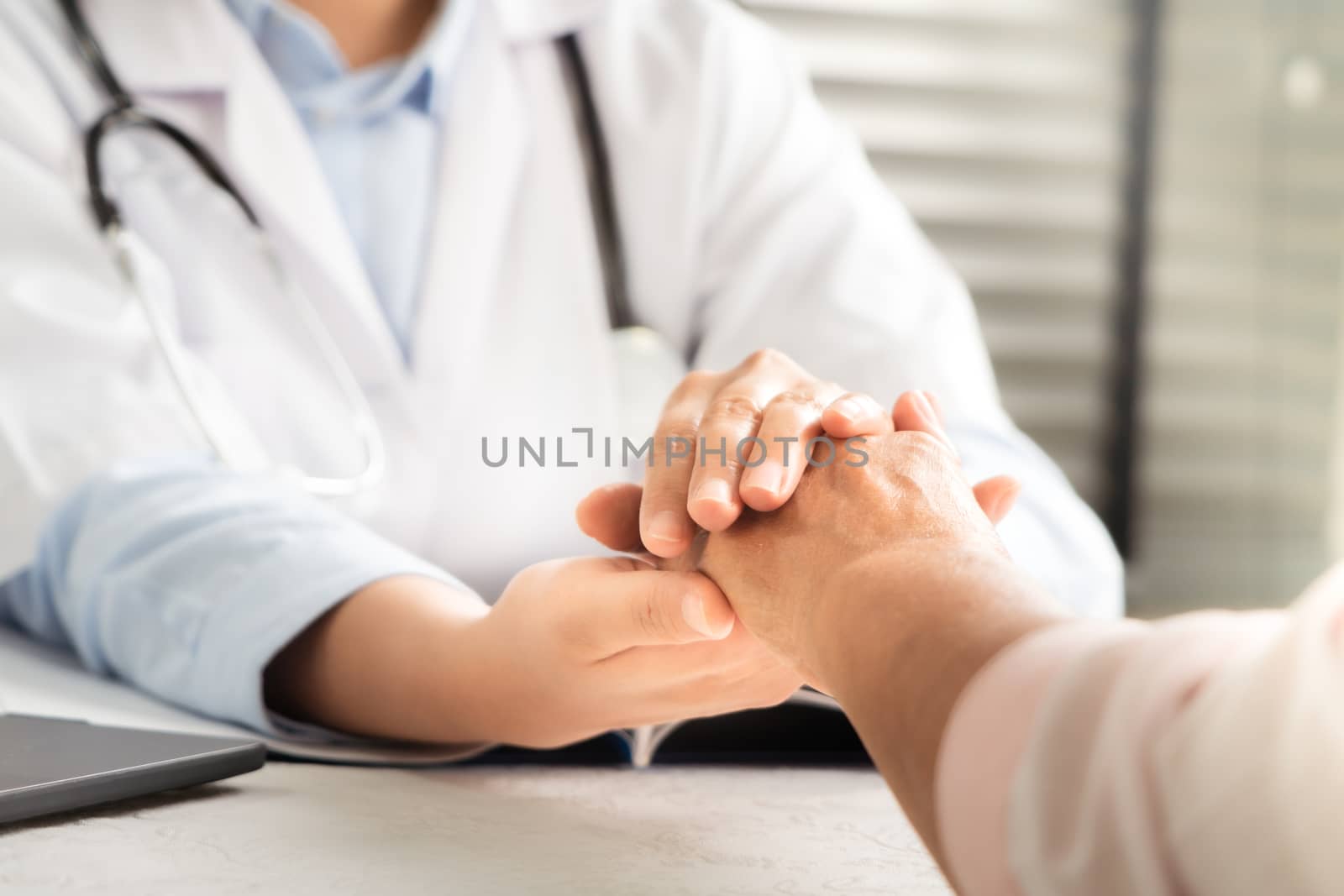 Doctor hands together holding senior woman patient