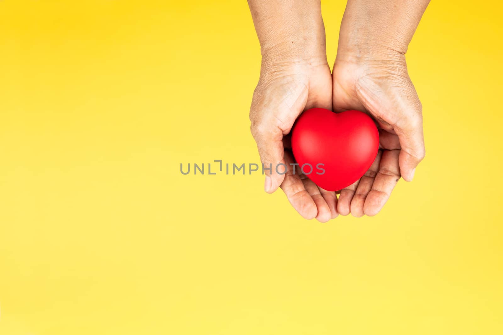 World health day concept Healthcare medical insurance with red heart on senior woman's hands support