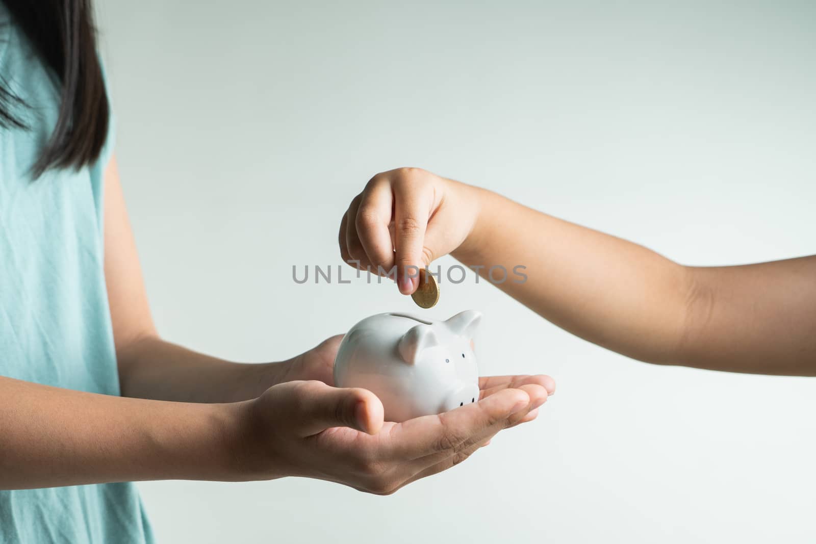 Saving and business concept, two little girl with piggy bank and coins at home