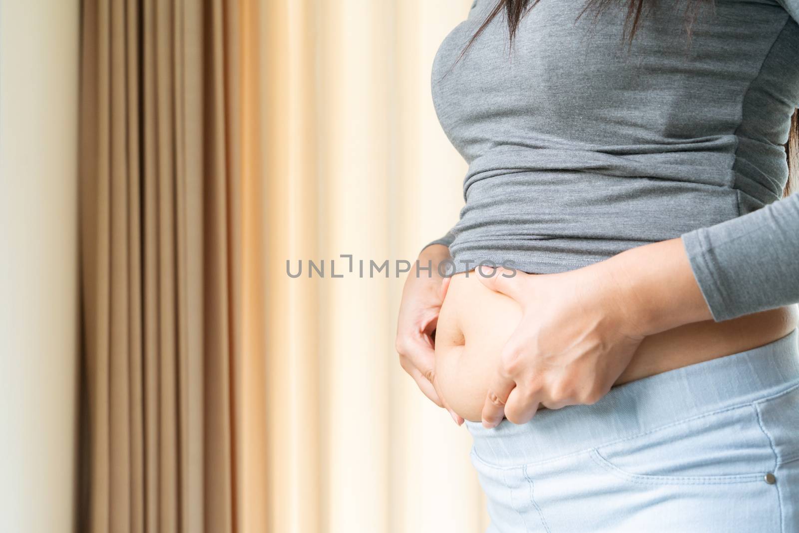 young woman's belly, women touch her fat belly, woman diet lifestyle concept