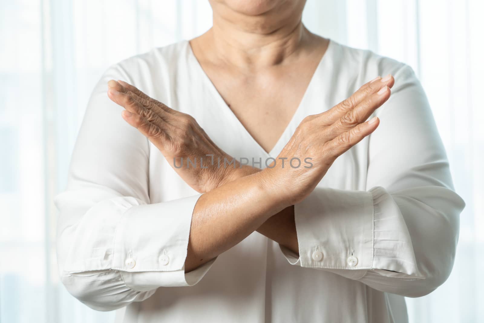 Senior asian woman say no holding two arms crossed