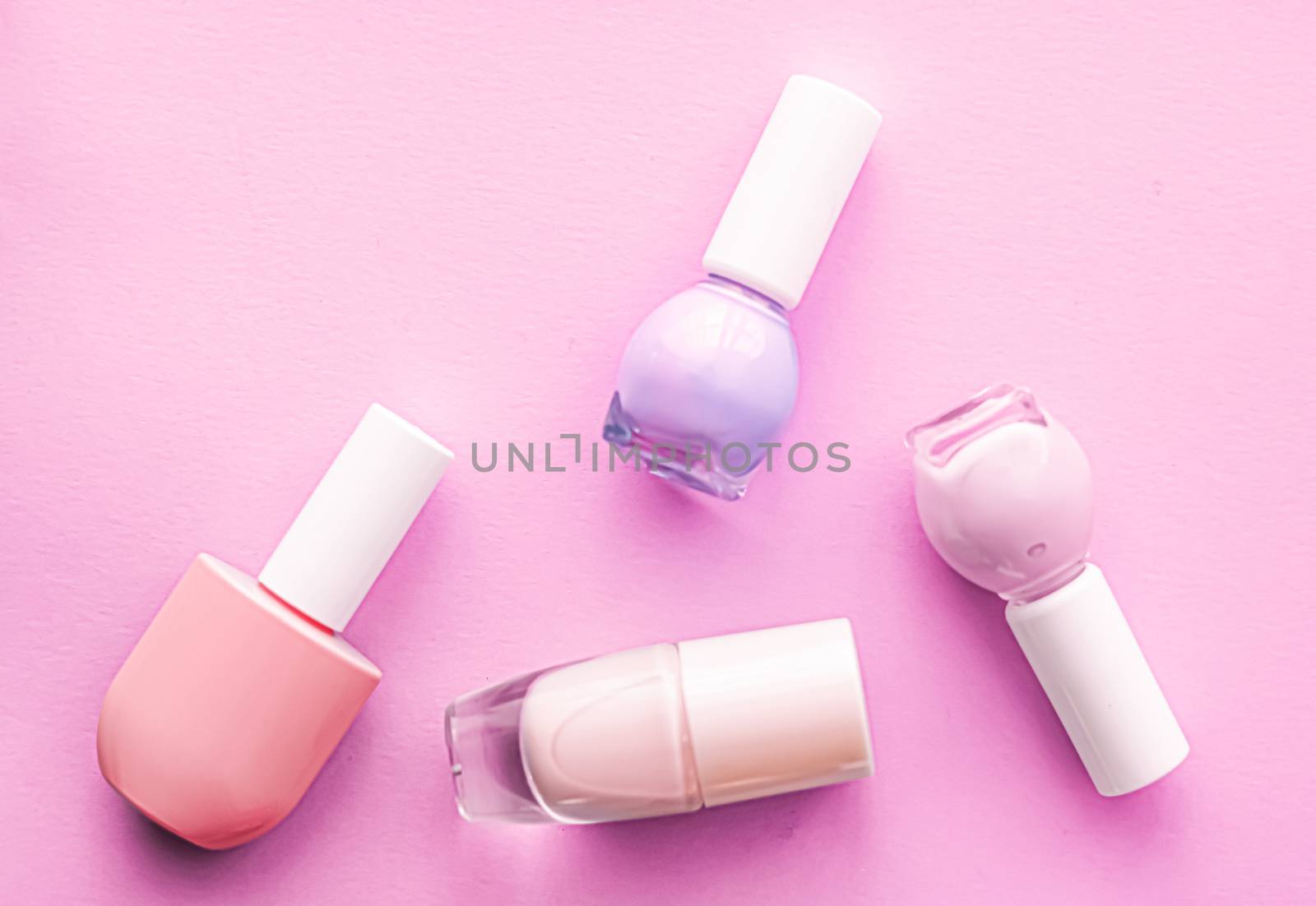 Nail polish bottles on pink background, beauty branding