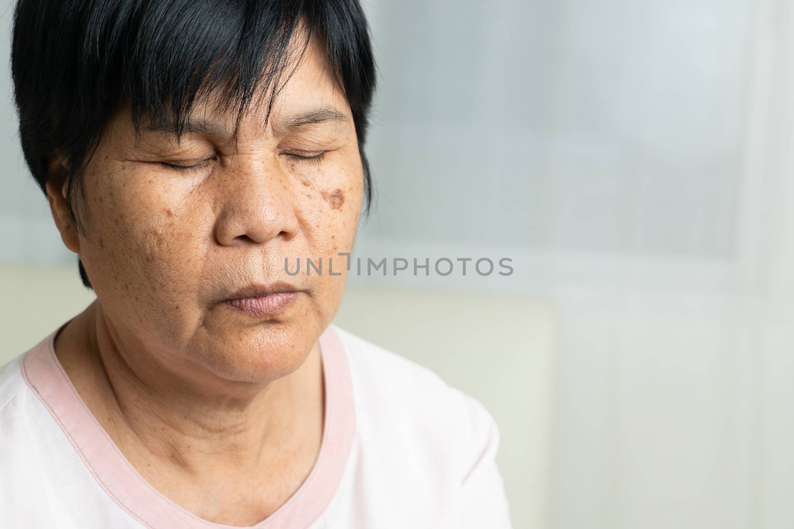 Close-up of Asian elder woman face with wrinkled skin condition by psodaz