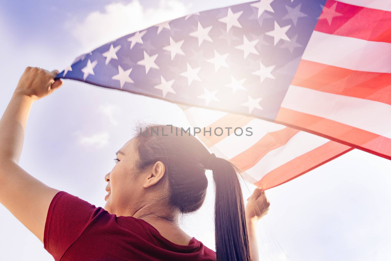 woman holding United States of America flag on sunny sky. USA Me by psodaz