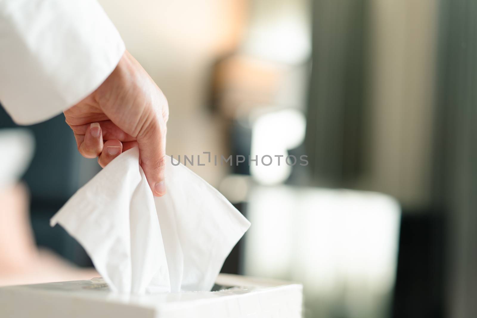 women hand picking napkin/tissue paper from the tissue box