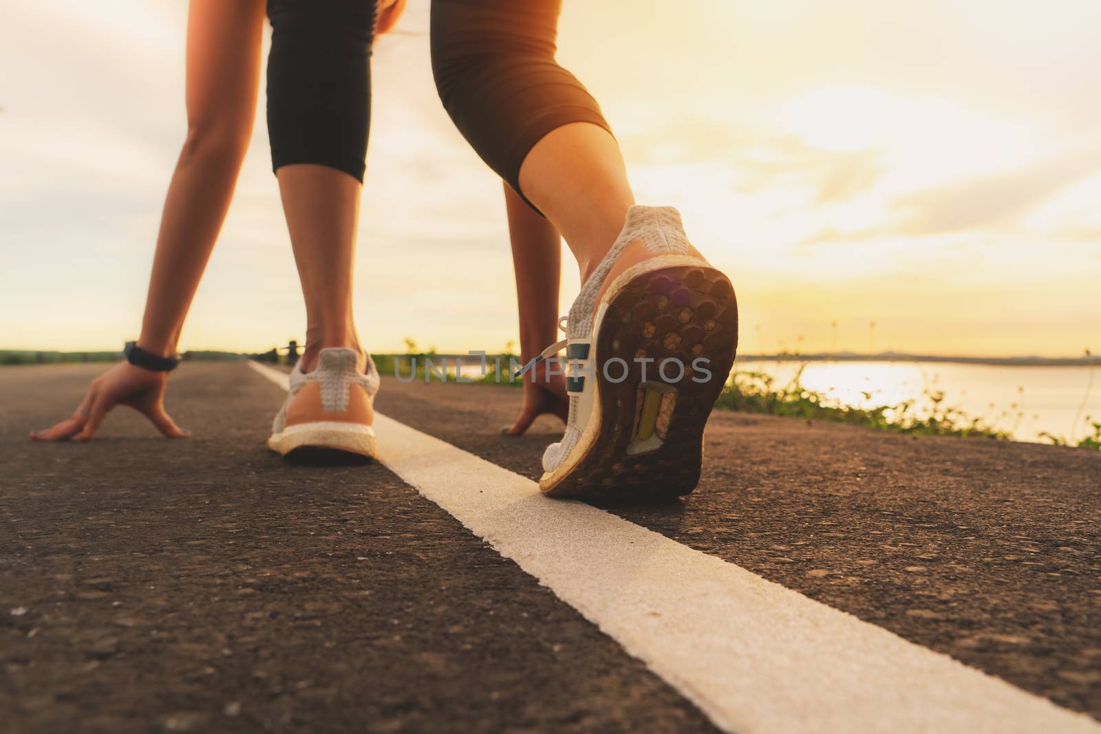 sport runner feet running on sunset lake closeup on shoe