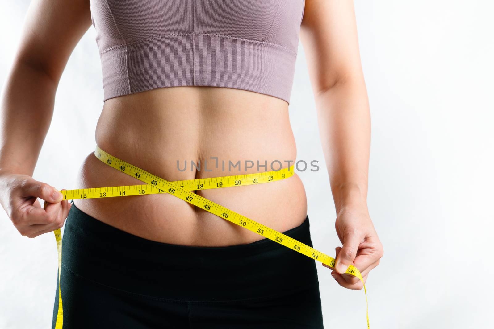 young woman measuring her excessive belly fat waist with measure by psodaz