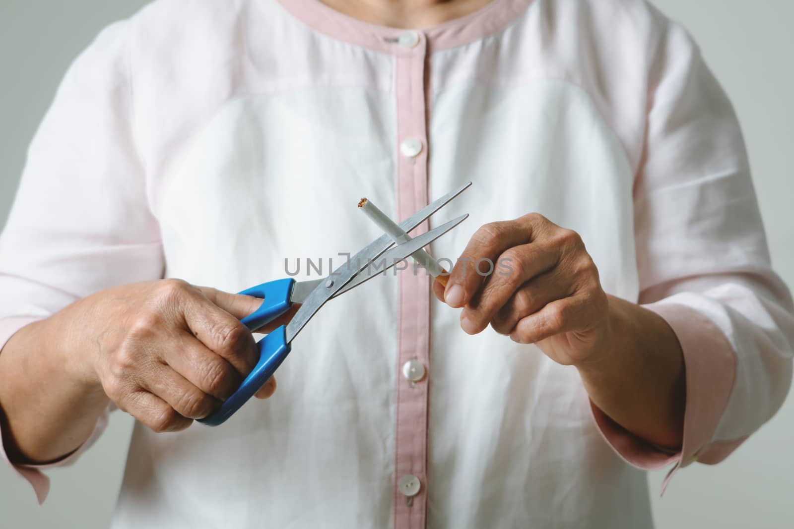 Quit smoking, no tobacco day, mother is cutting the cigarette