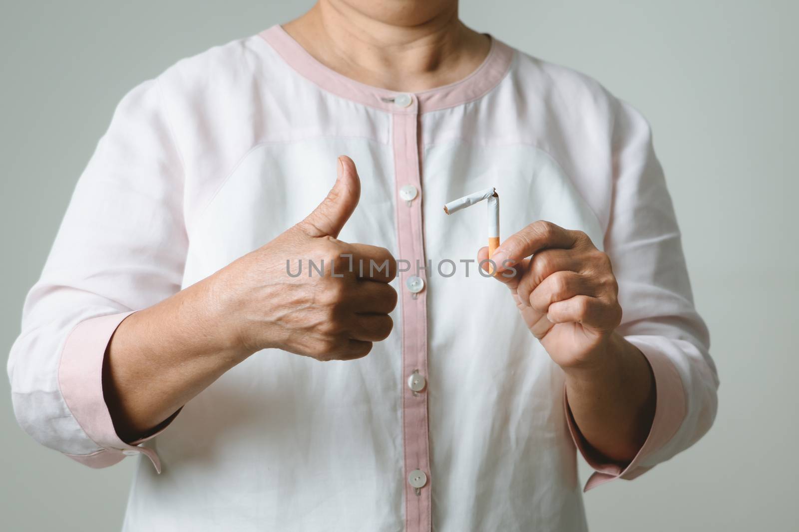 Quit smoking, no tobacco day, mother thumbs up with broken cigarette