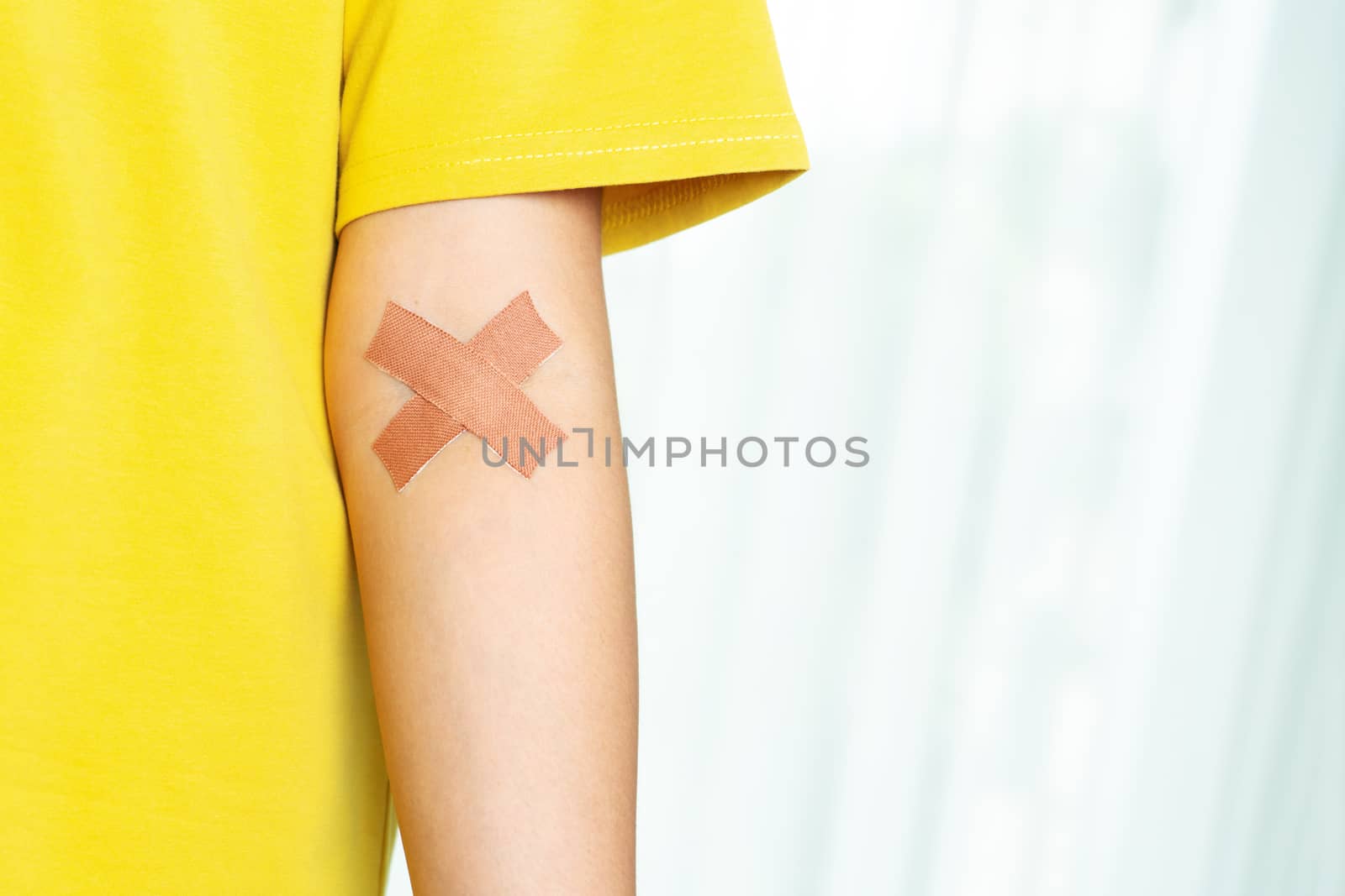 woman arm with a croos plaster. Blood donation concept by psodaz