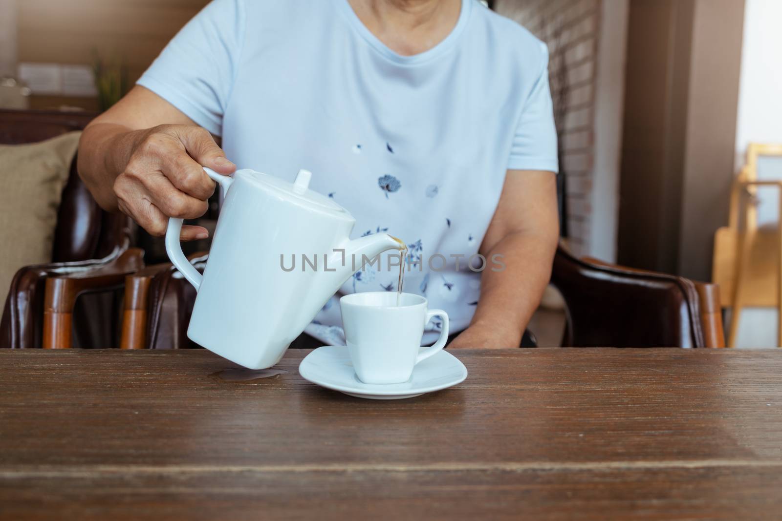 top view of a female pouring tea on wooden table