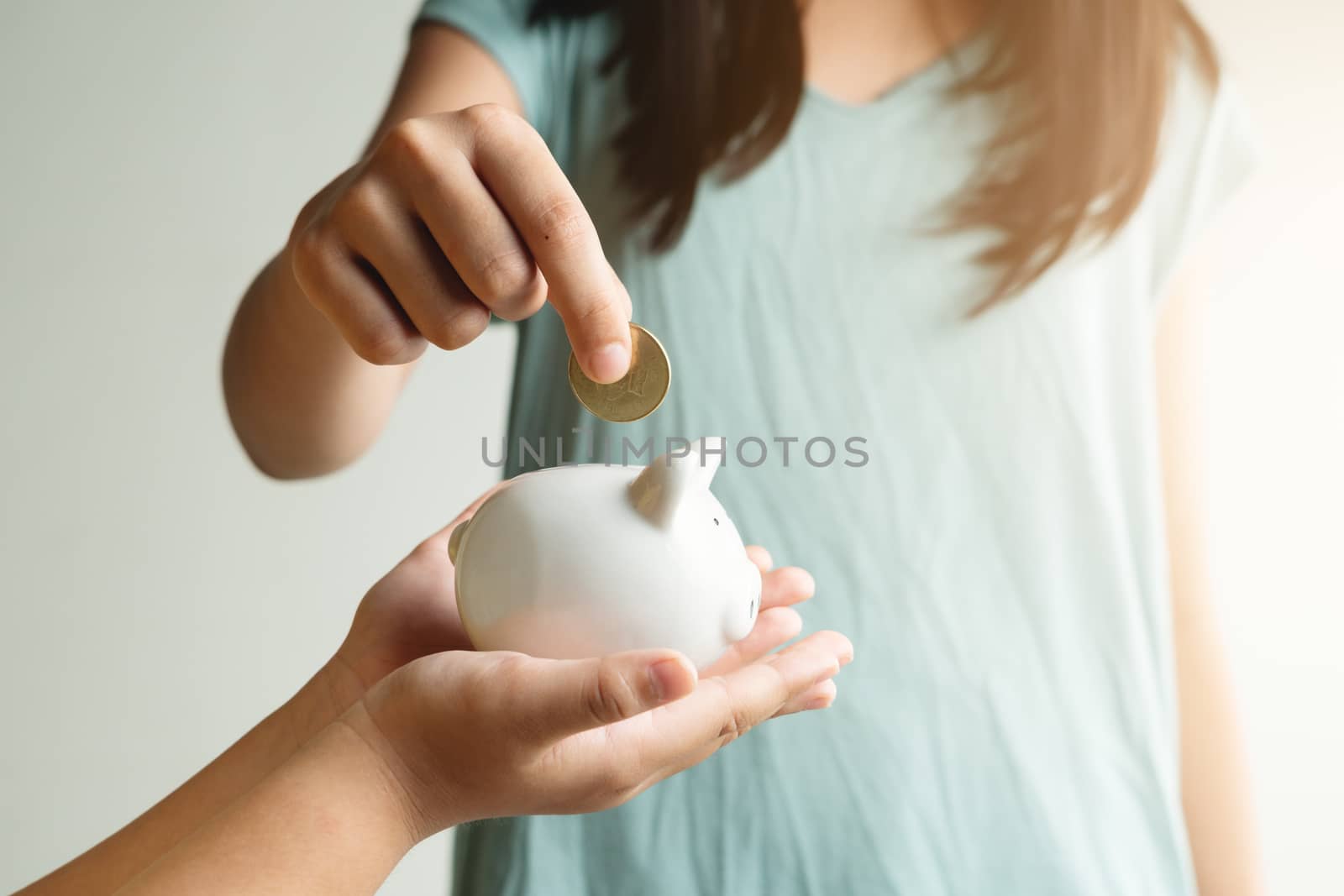 Saving and business concept, two little girl with piggy bank and by psodaz