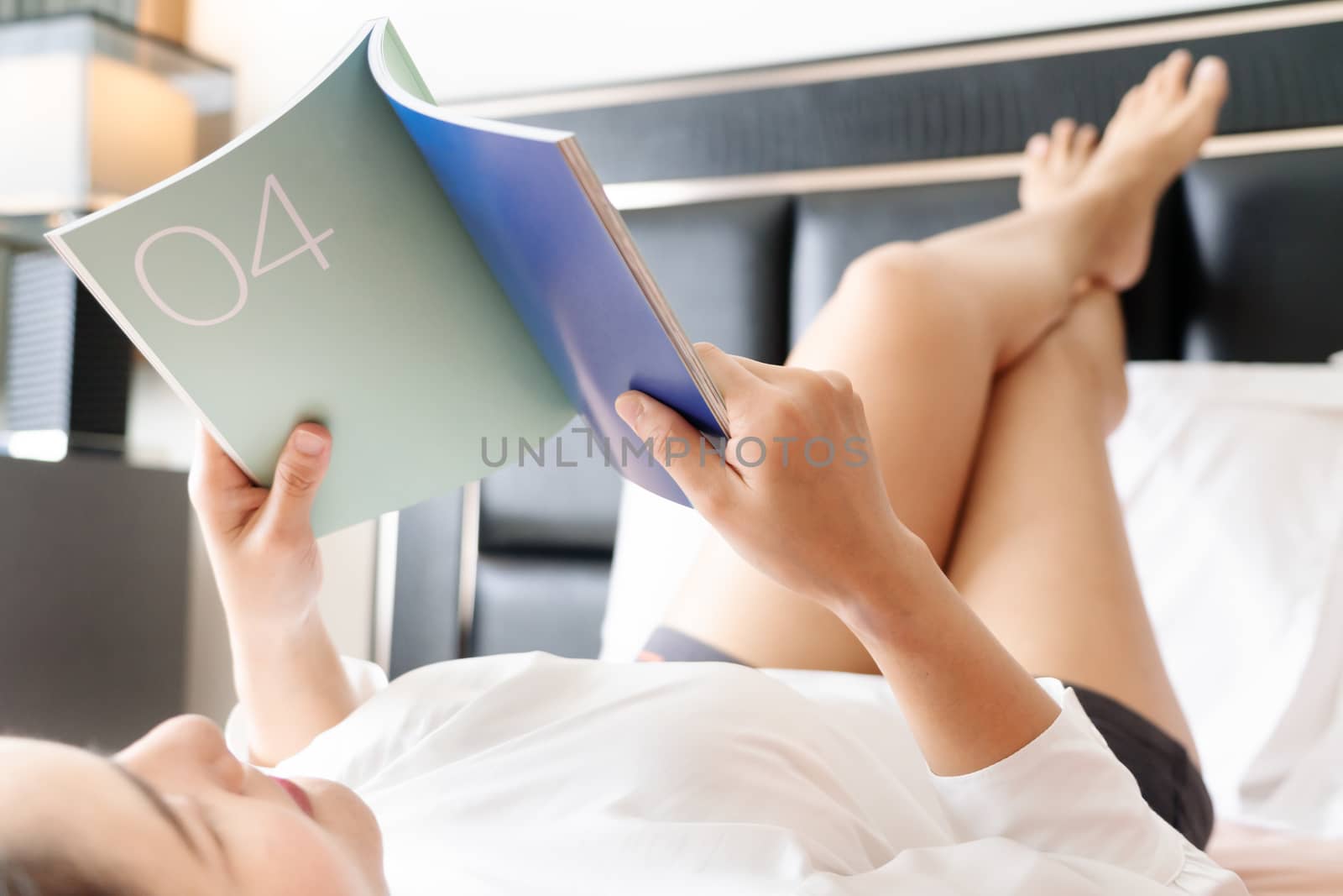 woman lay on bed reading the blank book