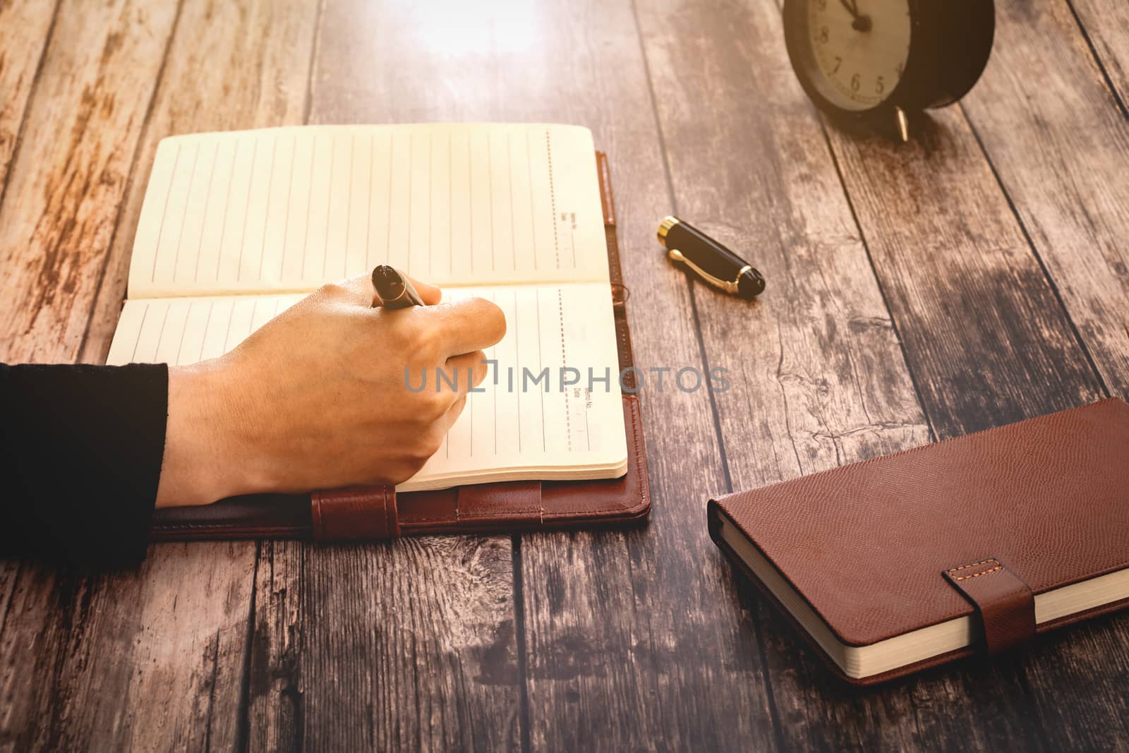 Woman hands drawing or writing,  on wooden table. retro filter