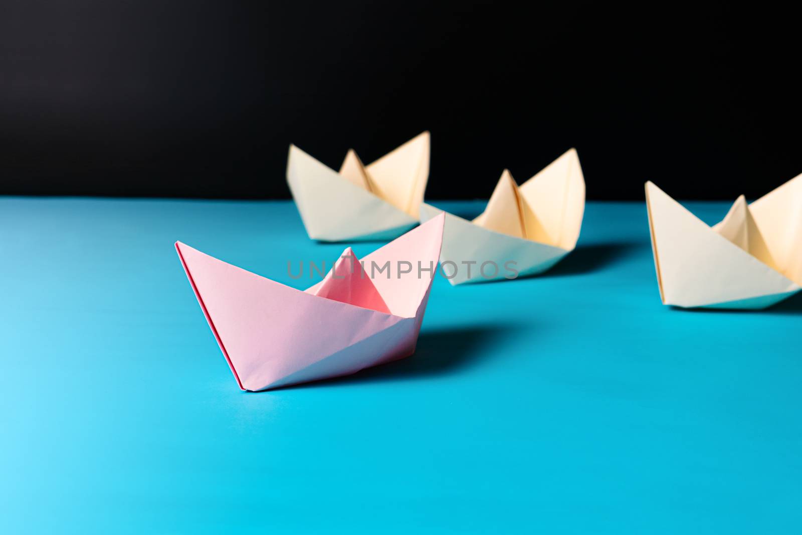 Leadership concept, pink paper ship lead yellow ship team member by psodaz