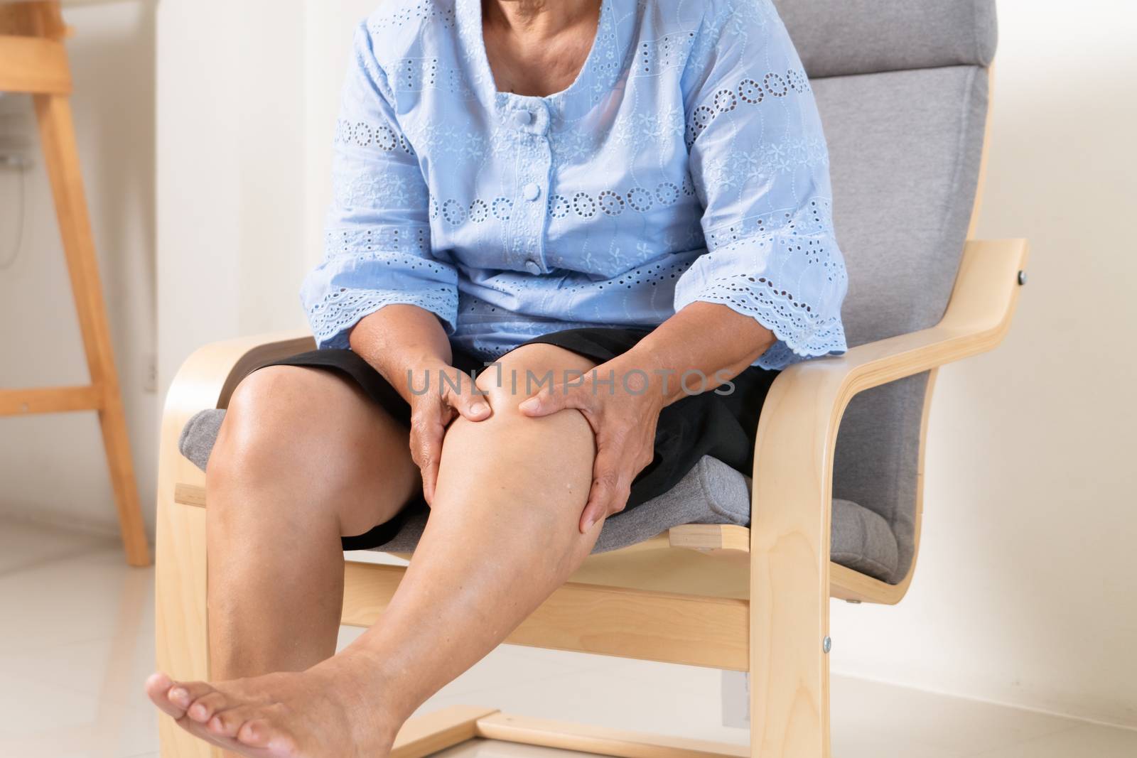 senior woman suffering from knee pain at home, health problem co by psodaz