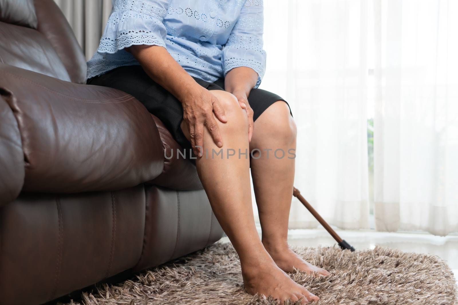 senior woman suffering from knee pain at home, health problem co by psodaz