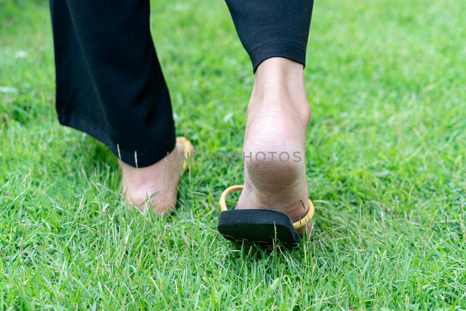 Dry heels feet of woman on grass by psodaz
