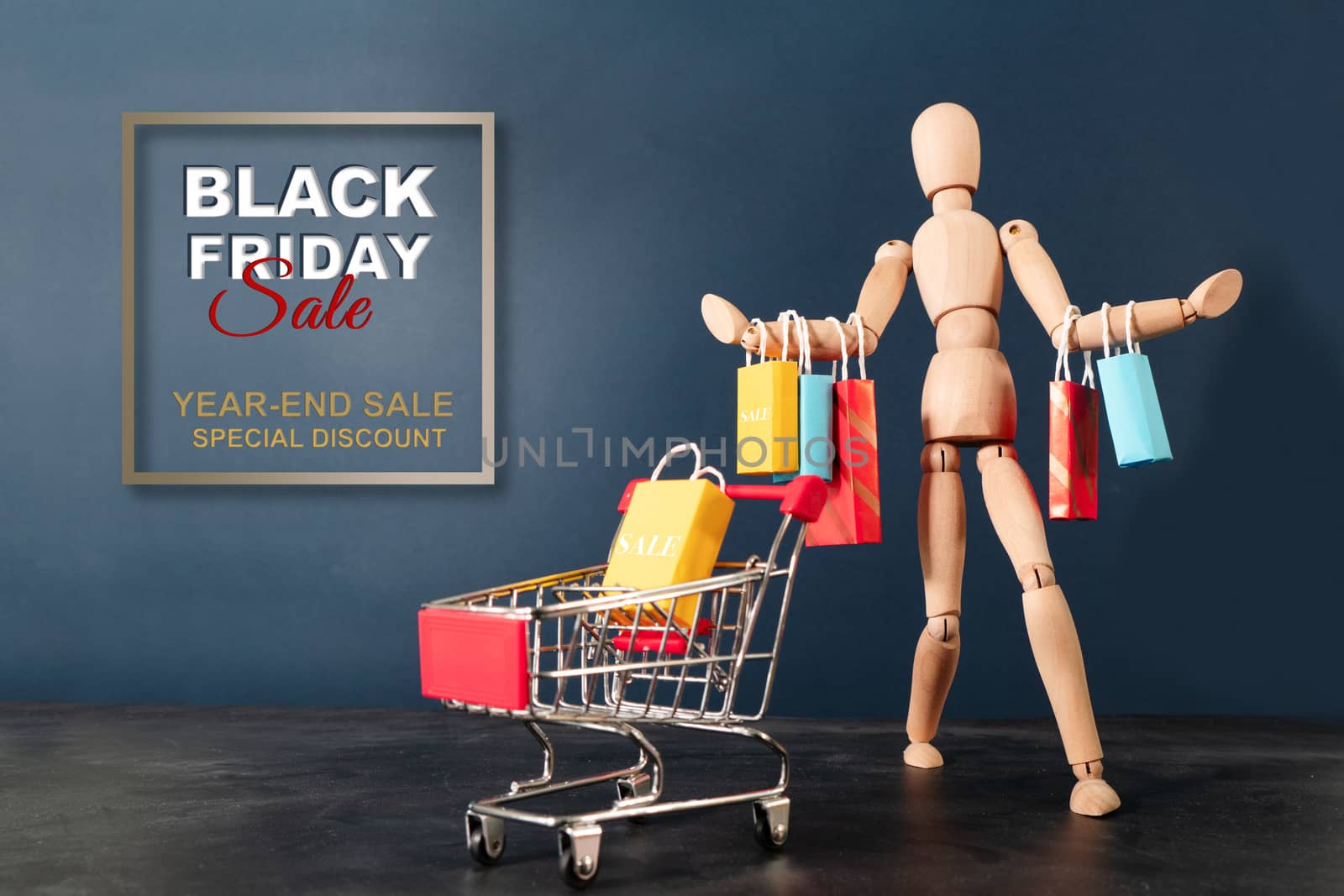 Black Friday sale, wooden doll sitting on shopping cart with shopping bag