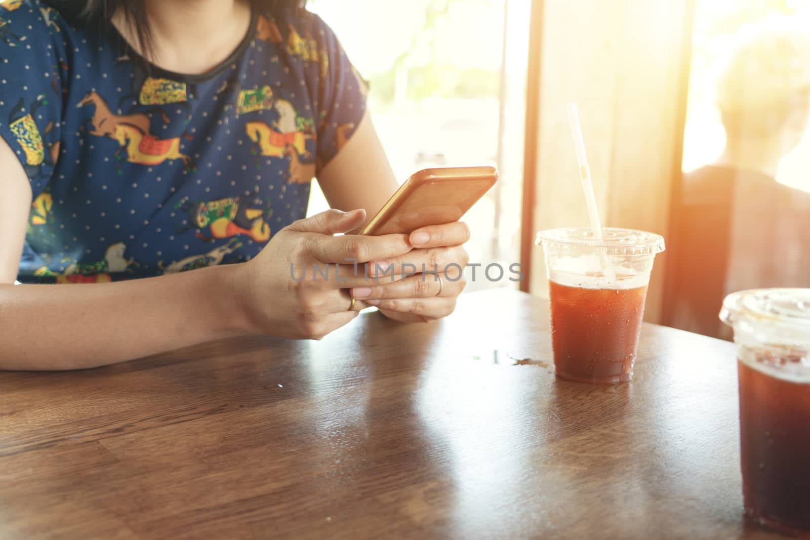 hand holding smartphone searching information on blurred background at coffee shop